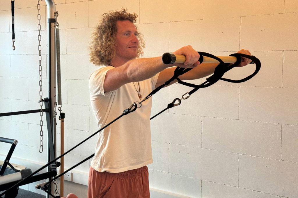 Trainer Gary performing Reformer Pilates exercise. He offers personal training and group classes.